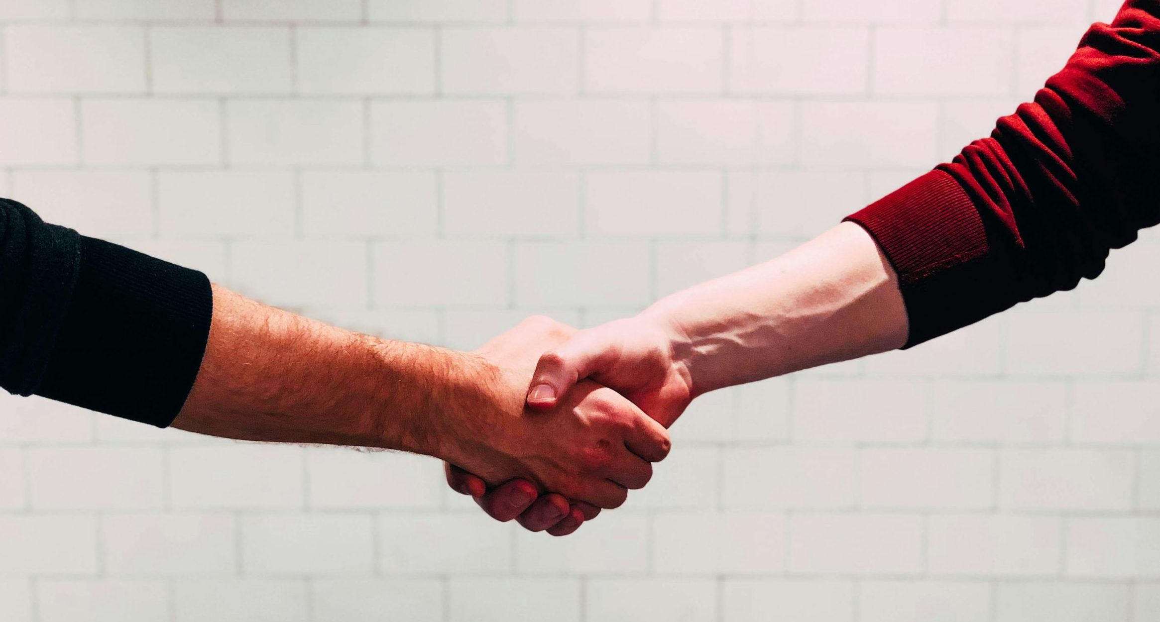 2 Menschen geben sich die Hand.